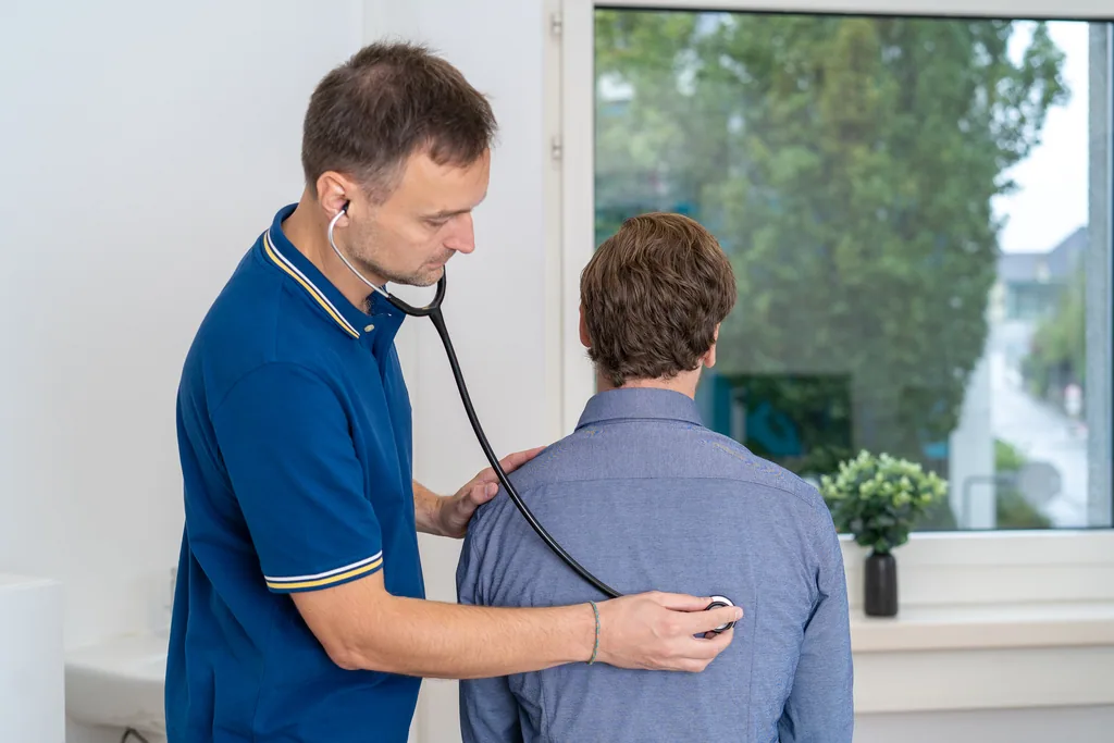 Arzt hört einen Patienten mit dem Stethoskop ab